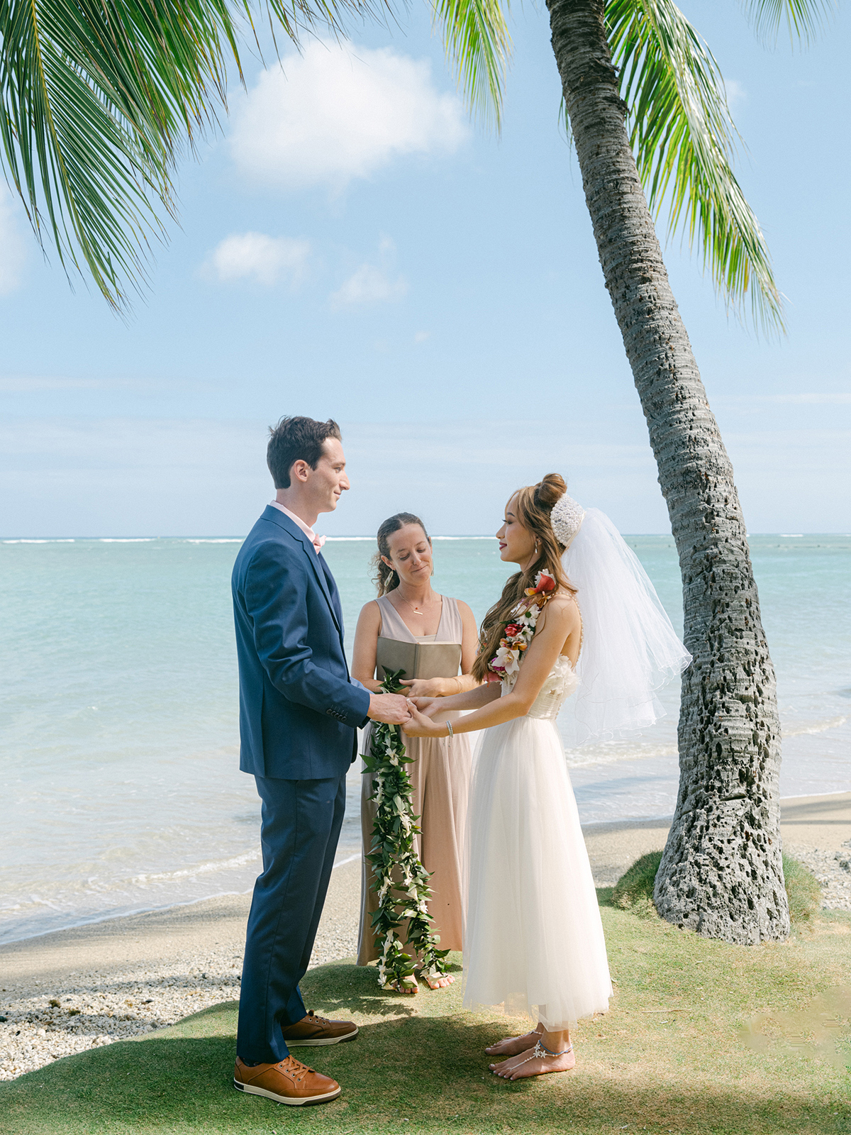 Small wedding ceremony at Waialae Beach on Oahu, Hawaii. Captured by Laura Ivanova Photography