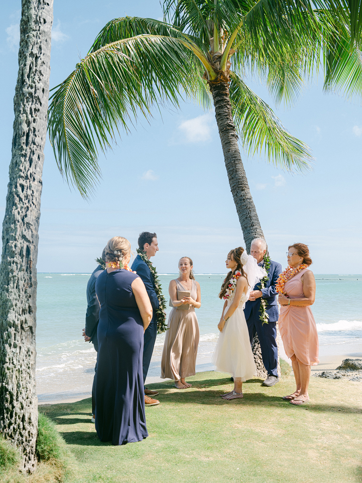 Small wedding ceremony at Waialae Beach on Oahu, Hawaii. Captured by Laura Ivanova Photography