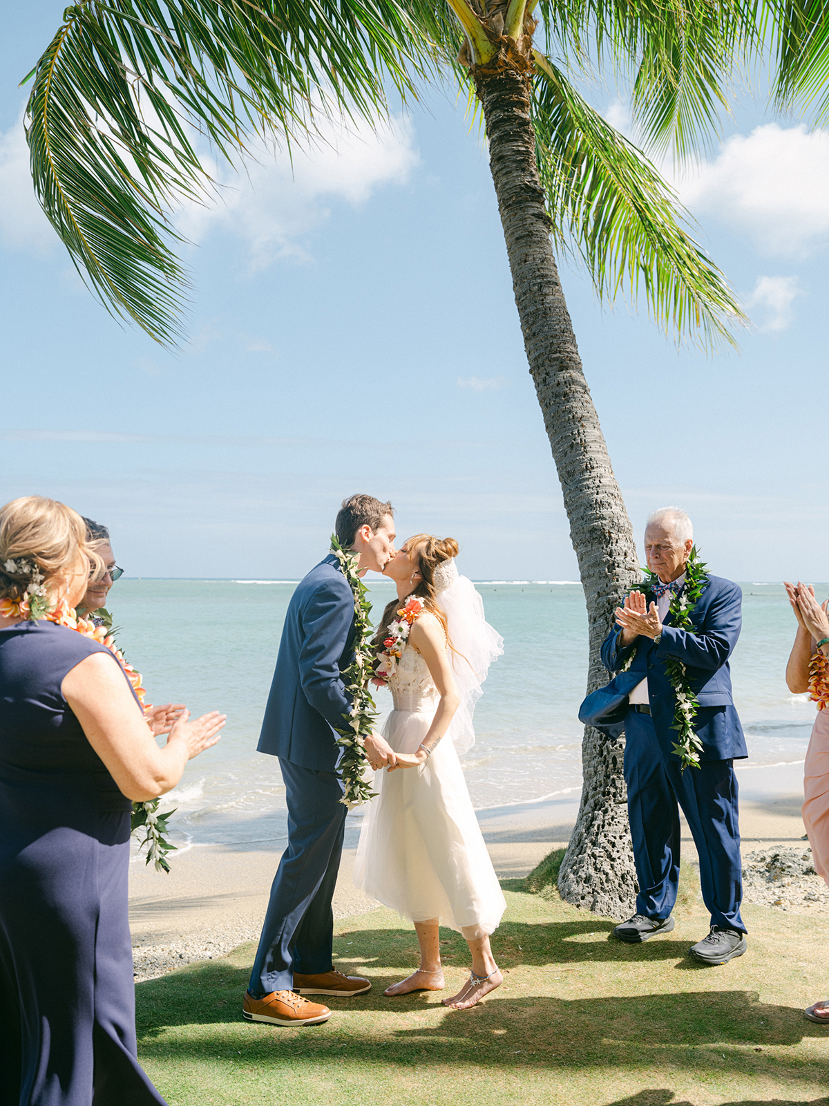 Small wedding ceremony at Waialae Beach on Oahu, Hawaii. Captured by Laura Ivanova Photography