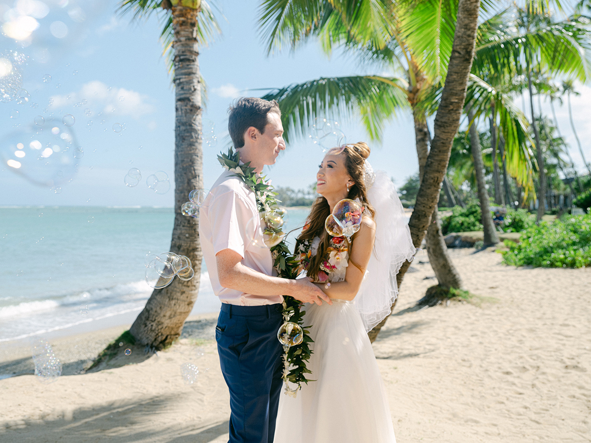 Small wedding ceremony at Waialae Beach on Oahu, Hawaii. Captured by Laura Ivanova Photography